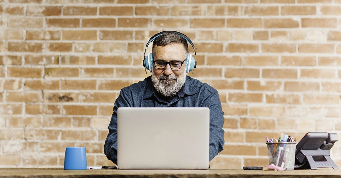 Mann mit Bart nutzt Laptop am Arbeitsplatz