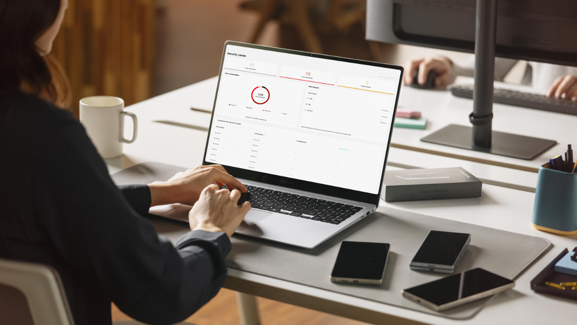 Samsung Knox einfache Verwaltung Frau richtet am Arbeitsplatz über das Notebook mehrere Smartphones ein
