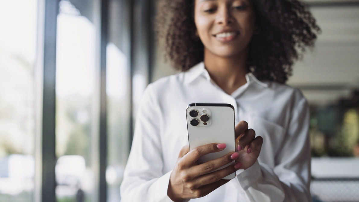 Mitarbeiterin hält neues iPhone 16 Pro in Hand