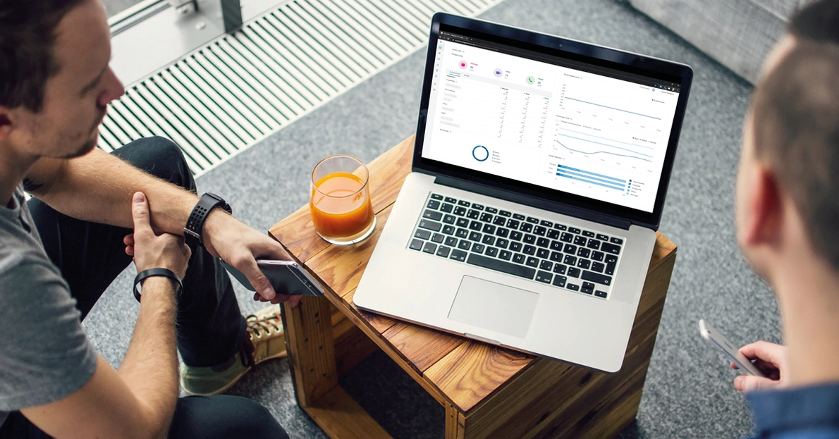 Zwei Mitarbeiter sitzen vor Notebook mit Analytics