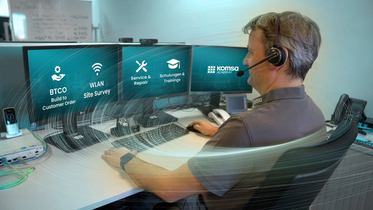 Arbeitsplatz im KOMSA Technical Assistance Center mit mehreren Monitoren und Headset