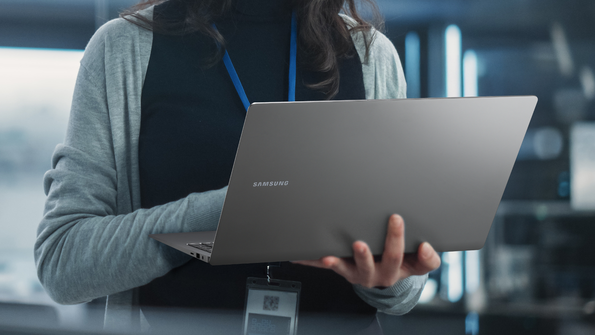 Samsung Notebooks im Business Mitarbeiterin hält Samsung Book in der Hand während sie darauf tippt