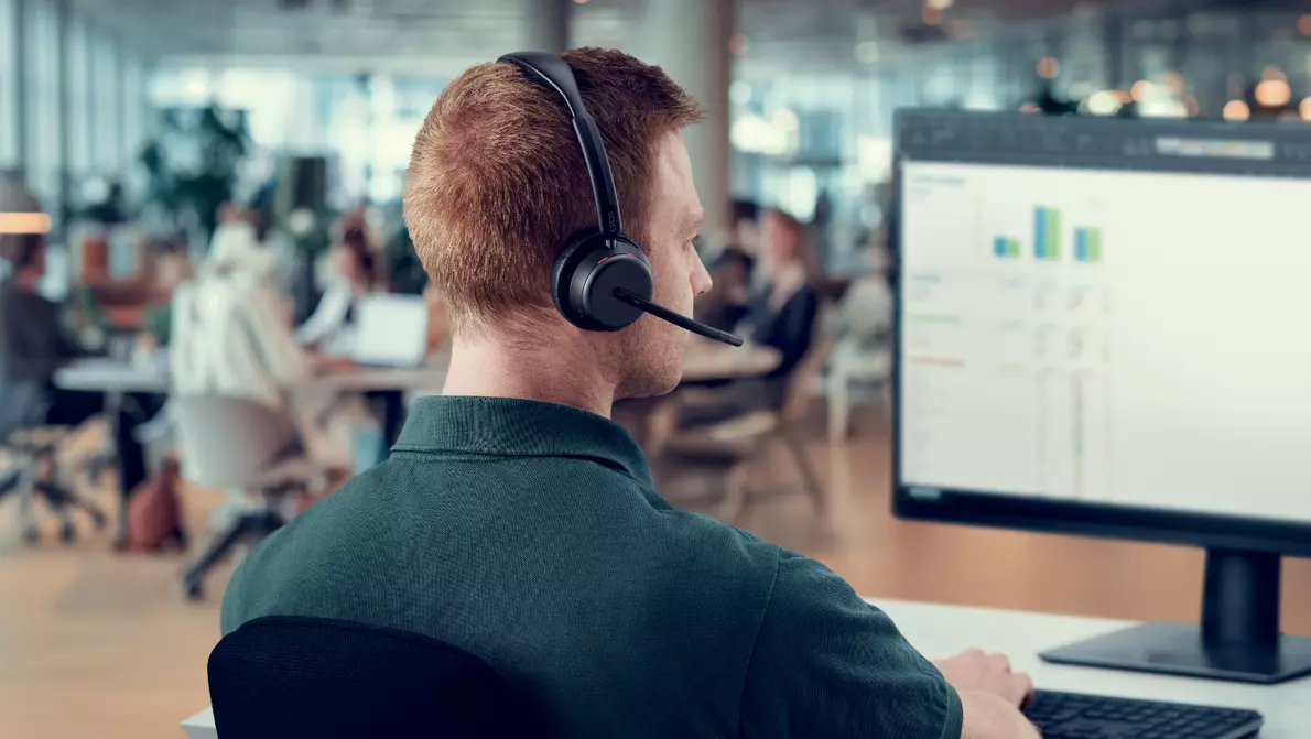 Blick über Schulter eines Mannes auf Monitor am Arbeitsplatz