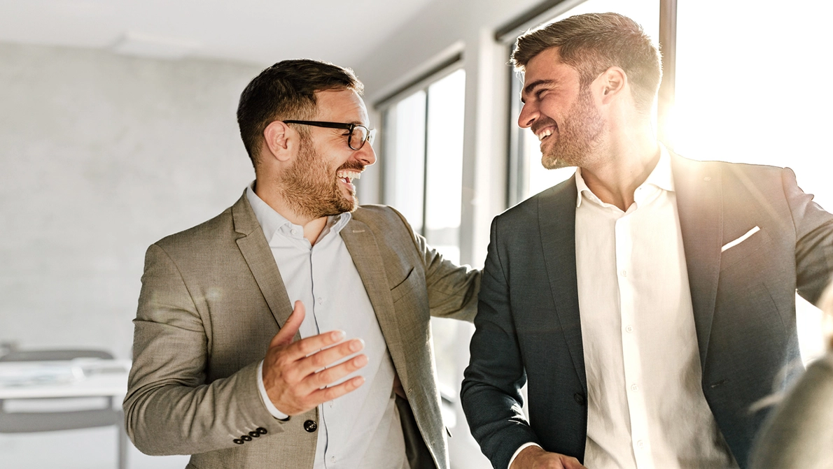 Plusnet Partner Portal Vorteile Zwei Kollegen reden freundlich im Büro miteinander