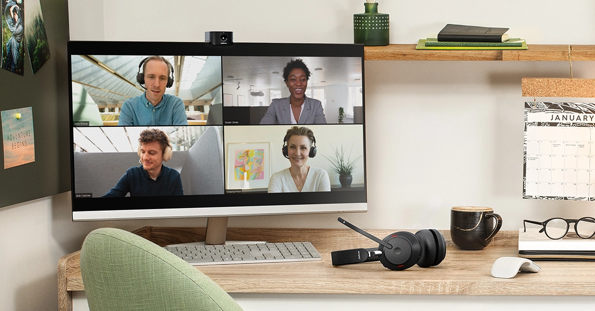 Eine Videokonferenz, übertragen auf einem Apple Mac. Neben der Tastatur liegt ein Headset von Jabra