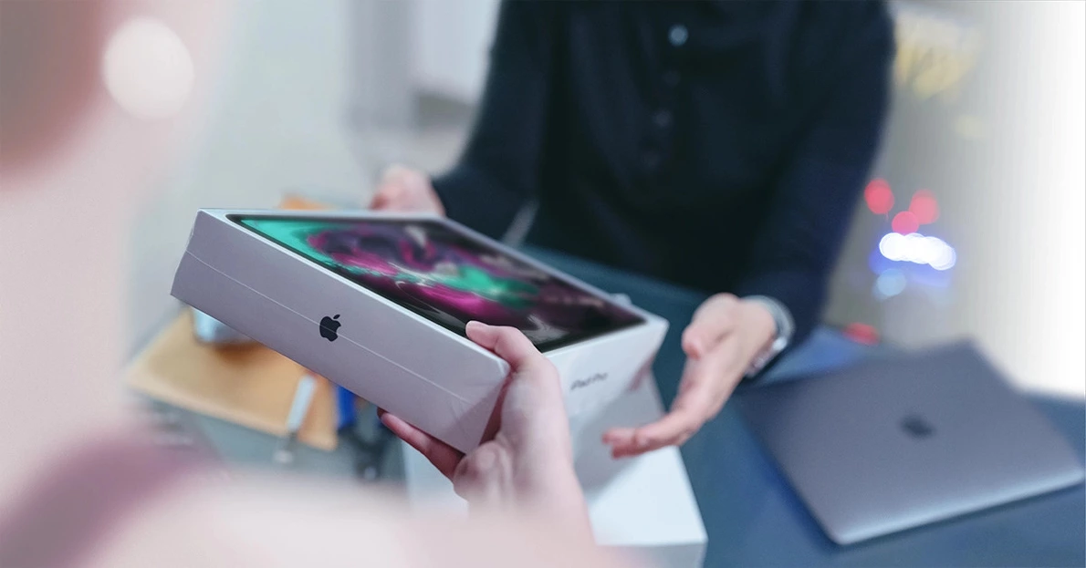 Frau übergibt original iPad an Mitarbeiter