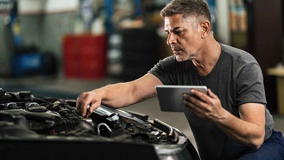 Mechaniker untersucht Motorraum eines PKW