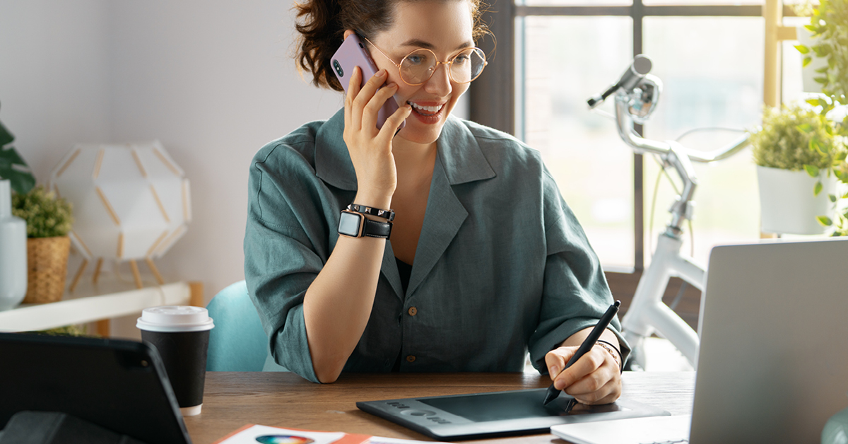 Frau arbeitet im Homeoffice und nutzt Smartphone, Tablet und Laptop