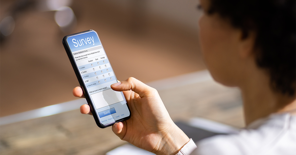 Frau haelt Smartphone mit Checkliste in der Hand