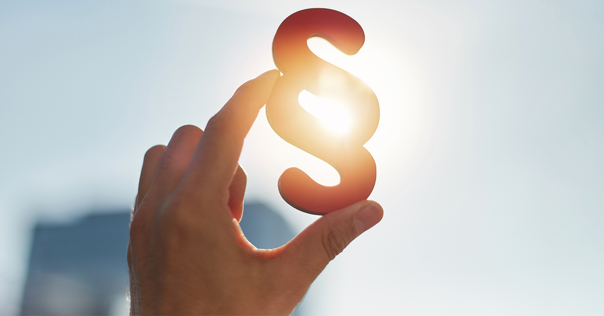 Paragraphen Symbol wird in der Hand gegen die Sonne gehalten